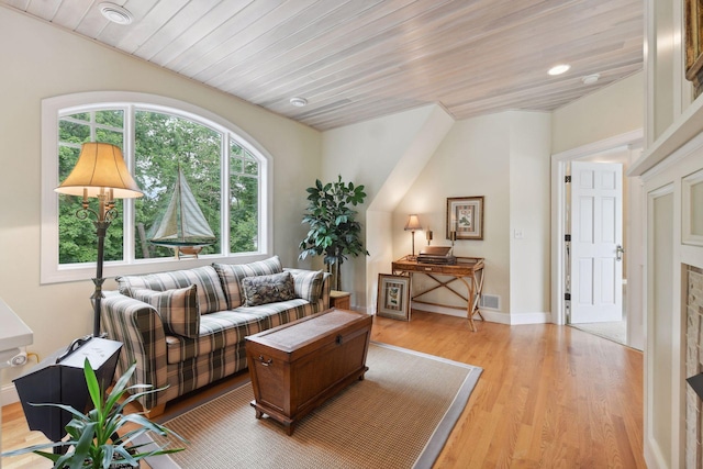 living room with light wood-type flooring, wood ceiling, and baseboards