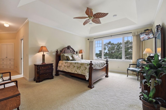 carpeted bedroom with baseboards, a raised ceiling, crown molding, and ceiling fan