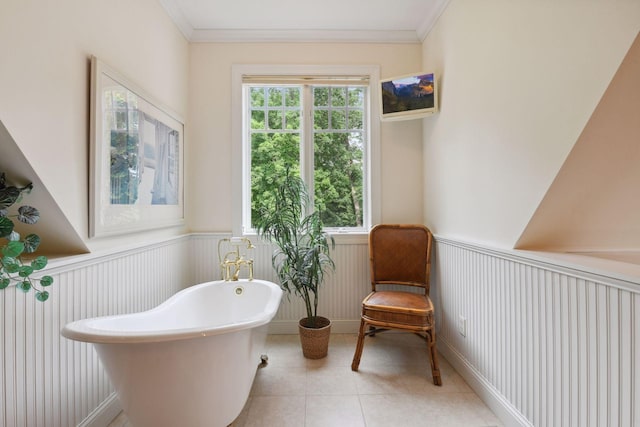 living area with wainscoting, ornamental molding, light tile patterned floors, and a decorative wall