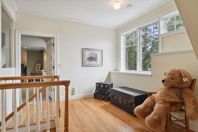 living area with light wood-style flooring, crown molding, and baseboards