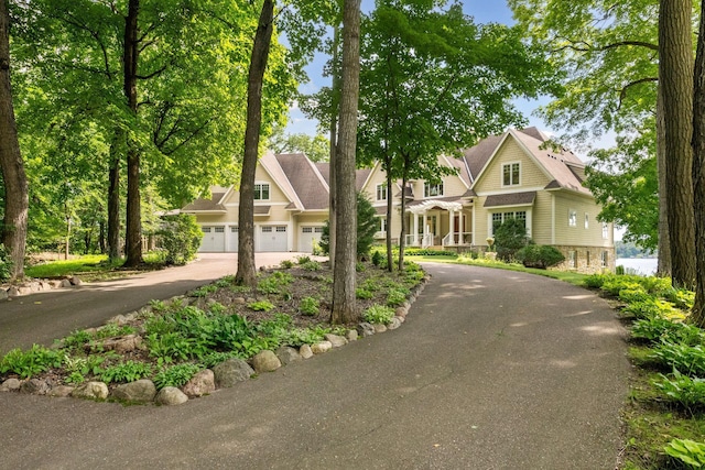 view of front facade featuring asphalt driveway and stone siding