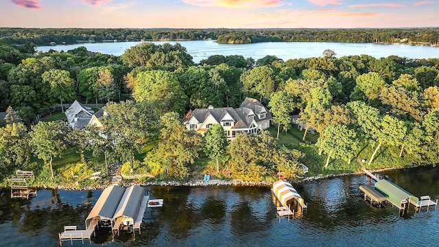 view of property location featuring a nearby body of water and a forest