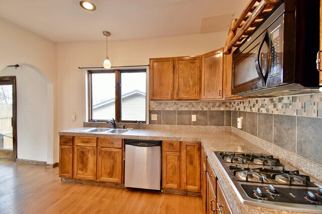 419 5th St NE, Staples, MN 56479 - kitchen featuring stainless steel appliances, a sink, brown cabinets, and light wood-style floors