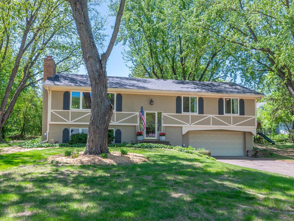 12875 Castleview Ct, Minnetonka, MN 55305 - view of front of home featuring stucco siding, a chimney, asphalt driveway, and a garage