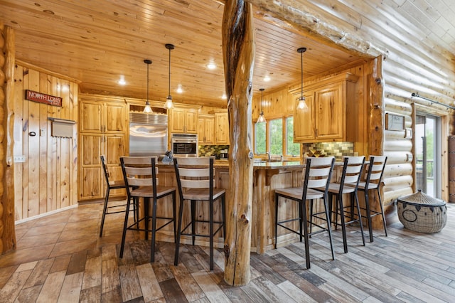 5784 Mcgowan Rd, Brainerd, MN 56401 - kitchen featuring wood ceiling, appliances with stainless steel finishes, a peninsula, light wood-style flooring, and a breakfast bar area