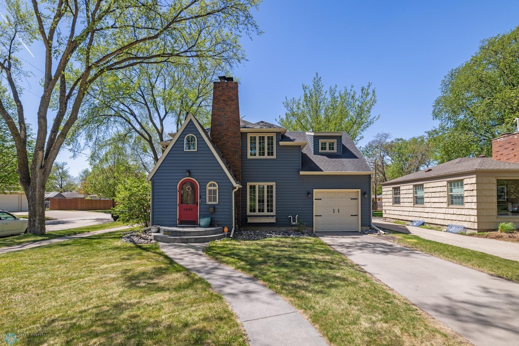 1449 10th St S, Fargo, ND 58103 - view of front of property with a garage, a front lawn, driveway, and a chimney