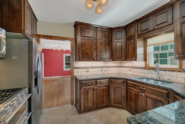 1317 8th Ave N, Saint Cloud, MN 56303 - kitchen with a sink, a chandelier, dark stone counters, and backsplash