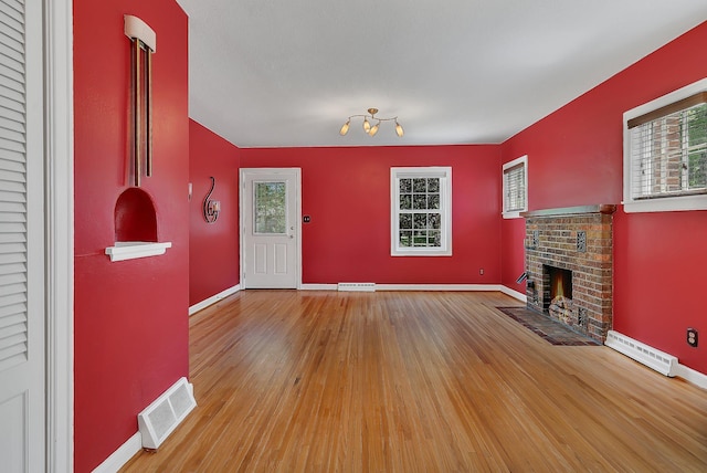 1317 8th Ave N, Saint Cloud, MN 56303 - entryway with wood finished floors, a fireplace, baseboards, and a baseboard radiator