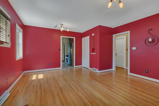 1317 8th Ave N, Saint Cloud, MN 56303 - unfurnished room featuring light wood-style floors, baseboards, and a baseboard heating unit