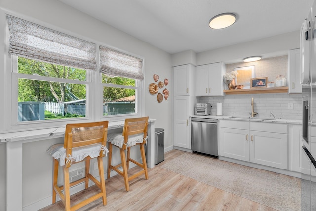 816 5th St S, Stillwater, MN 55082 - kitchen with dishwasher, a sink, light wood finished floors, decorative backsplash, and white cabinetry