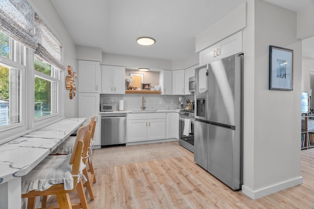 816 5th St S, Stillwater, MN 55082 - kitchen with stainless steel appliances, open shelves, light wood-type flooring, and a sink