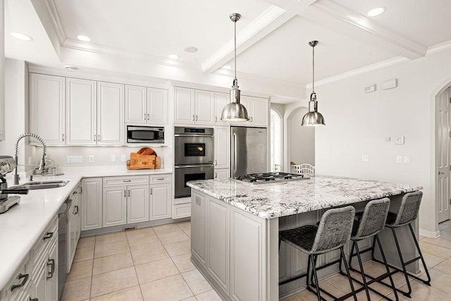 kitchen featuring arched walkways, a sink, appliances with stainless steel finishes, a kitchen island, and light tile patterned floors