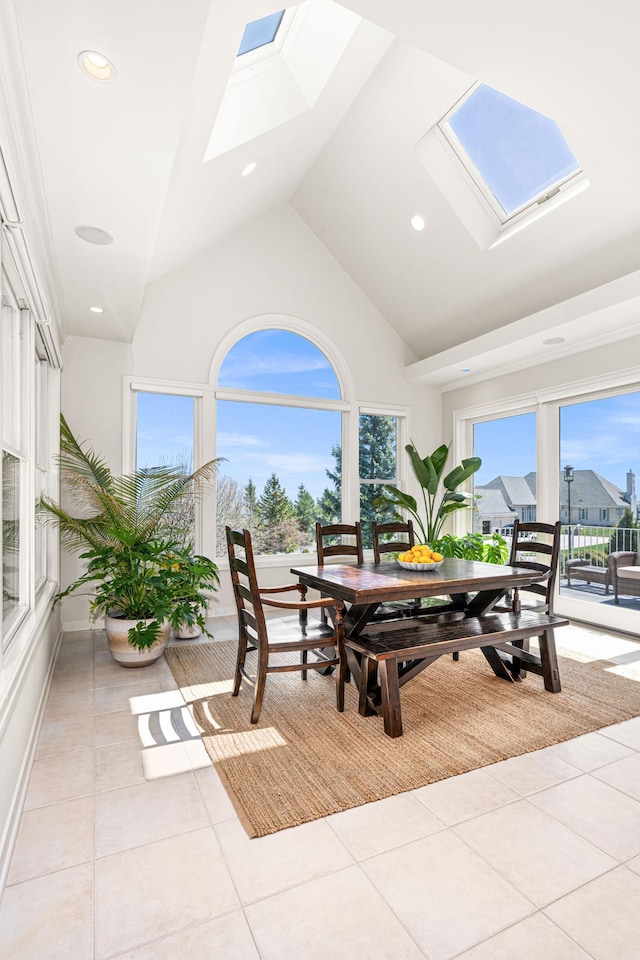 dining area featuring a skylight, light tile patterned floors, high vaulted ceiling, and recessed lighting