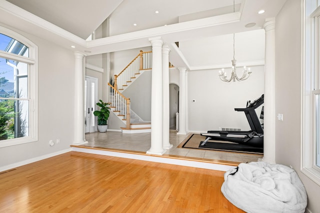workout area with plenty of natural light, wood finished floors, decorative columns, lofted ceiling, and recessed lighting