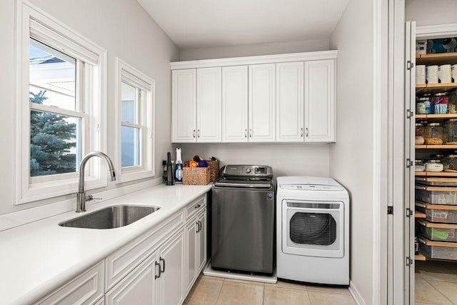laundry area with cabinet space, washing machine and clothes dryer, and light tile patterned floors