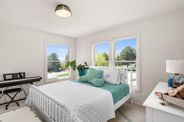 bedroom with light carpet and baseboards