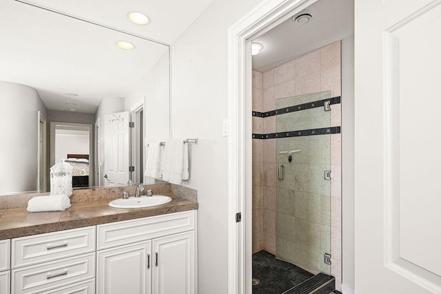 bathroom with a stall shower, vanity, and recessed lighting