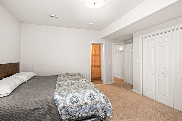 bedroom featuring light colored carpet and a closet