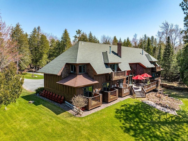 89405 Jack Pine Rd, Cornucopia, WI 54827 - back of property with board and batten siding, a chimney, and a yard
