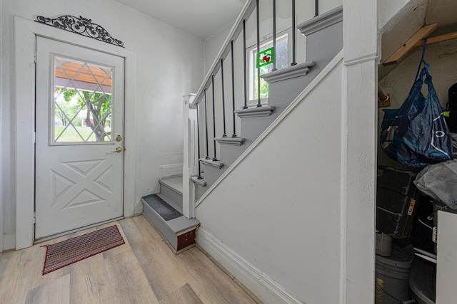 foyer entrance with light wood finished floors and stairway
