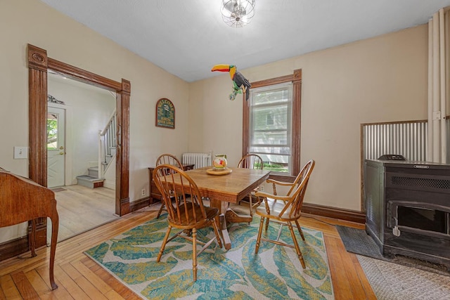 dining space with plenty of natural light, light wood finished floors, radiator heating unit, and stairway