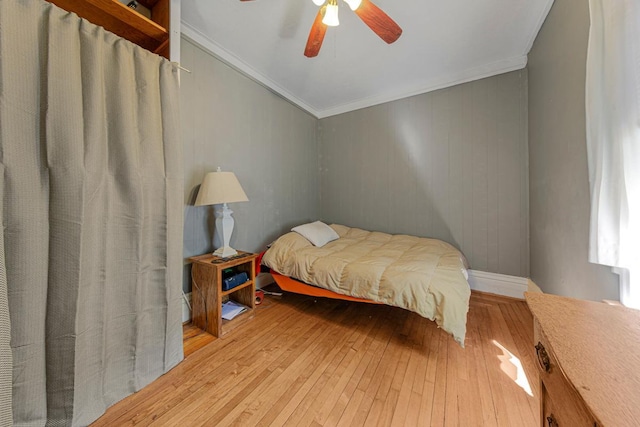 bedroom with light wood finished floors, crown molding, and a ceiling fan