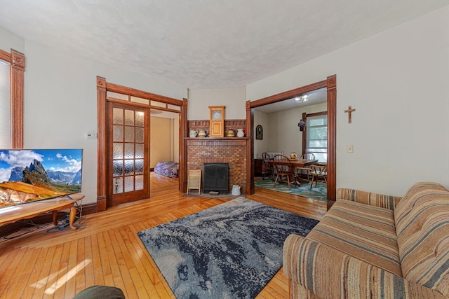 living area featuring hardwood / wood-style floors, a fireplace, and french doors