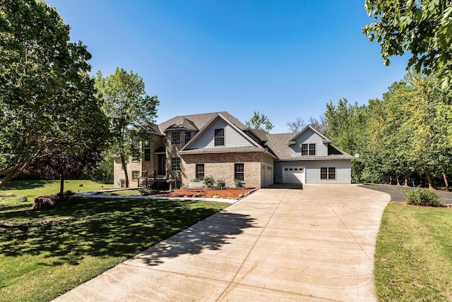 view of front of house with driveway, a garage, brick siding, and a front yard