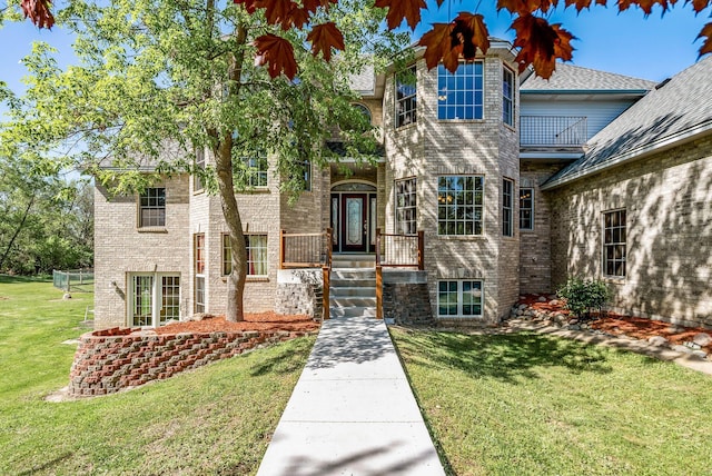 view of front of house with a front lawn and brick siding