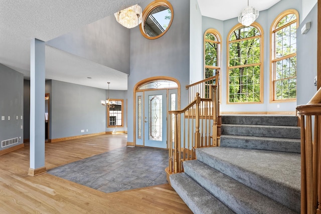 foyer entrance featuring a chandelier, wood finished floors, and stairs
