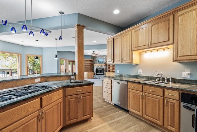 kitchen featuring dishwasher, a sink, gas cooktop, ceiling fan, and a textured ceiling
