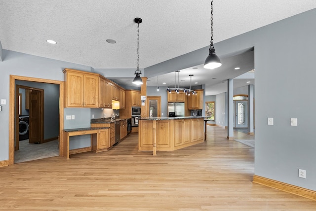 kitchen with stainless steel appliances, light wood finished floors, baseboards, a textured ceiling, and hanging light fixtures