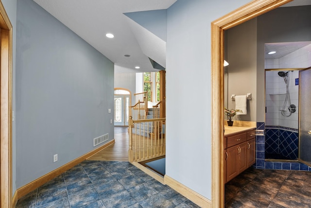 hall with recessed lighting, baseboards, stairway, and arched walkways
