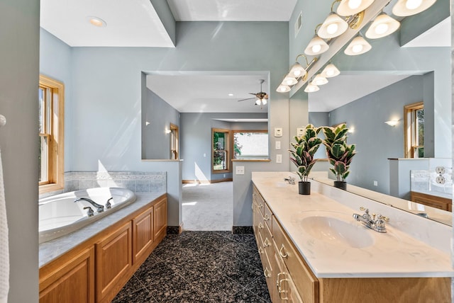 full bathroom with granite tiled floors, a ceiling fan, baseboards, double vanity, and a garden tub