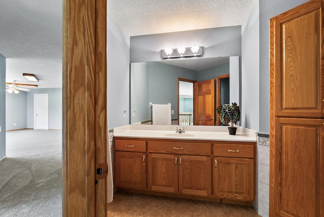 bathroom featuring a textured ceiling, vanity, and ceiling fan