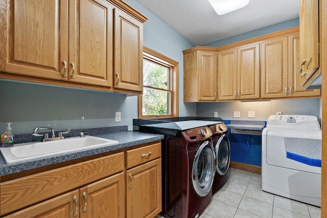 clothes washing area featuring washer and clothes dryer, cabinet space, light tile patterned floors, and a textured ceiling