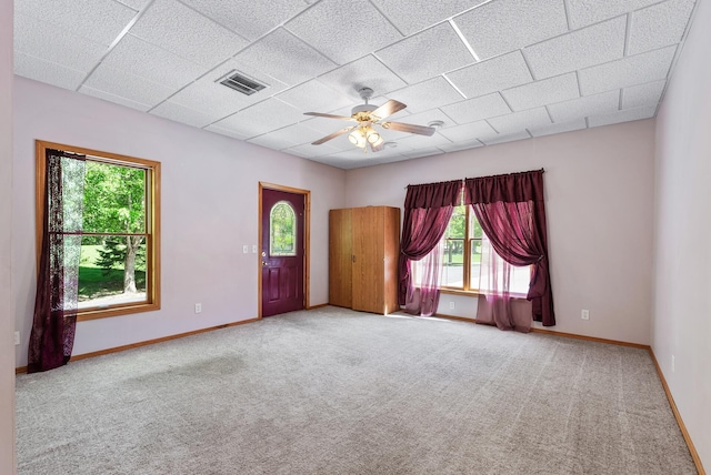 spare room with carpet floors, a ceiling fan, baseboards, and a drop ceiling