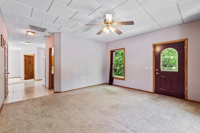 carpeted entryway featuring a ceiling fan, baseboards, and tile patterned floors