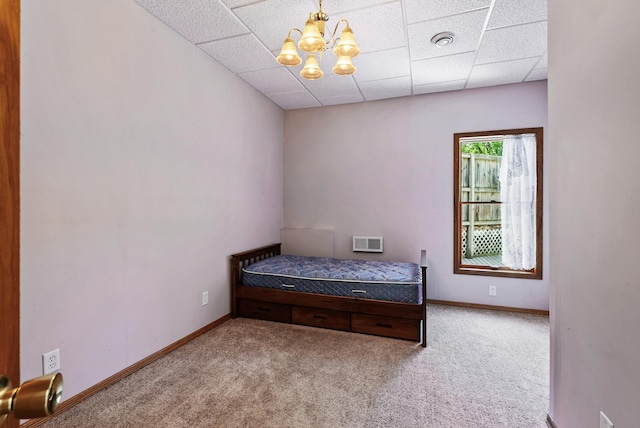 bedroom with carpet, a chandelier, a paneled ceiling, and baseboards