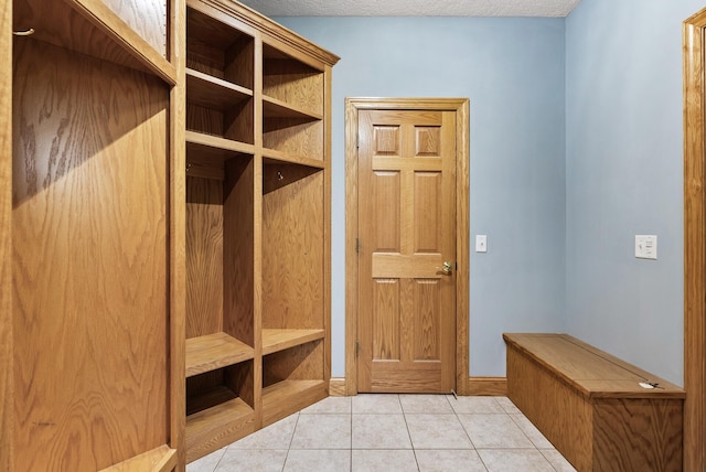 mudroom with light tile patterned flooring and a textured ceiling