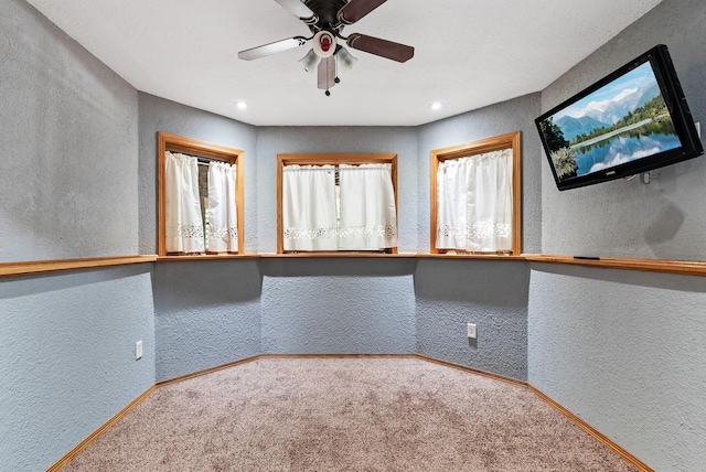 carpeted empty room featuring a textured wall, a ceiling fan, baseboards, and recessed lighting