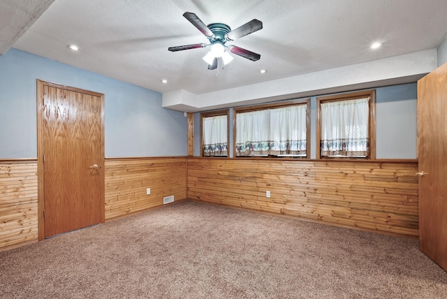 spare room with wooden walls, carpet, a wainscoted wall, a ceiling fan, and recessed lighting