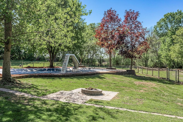 view of yard featuring an outdoor fire pit and view of scattered trees