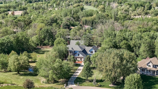 aerial view of property and surrounding area with a heavily wooded area