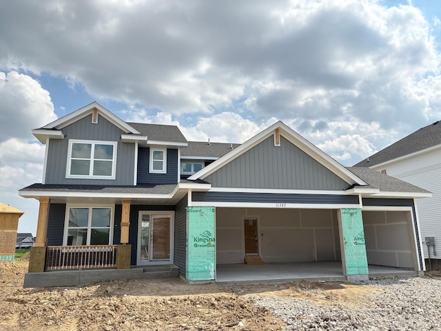 11367 84th St NE, Otsego, MN 55330 - unfinished property with covered porch, a garage, roof with shingles, and board and batten siding