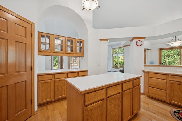 217 Canyon Dr, Hudson, WI 54016 - kitchen with light wood-style floors, light countertops, a center island, glass insert cabinets, and vaulted ceiling