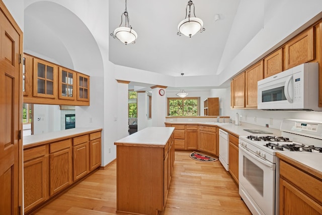 217 Canyon Dr, Hudson, WI 54016 - kitchen featuring white appliances, vaulted ceiling, light wood-type flooring, a kitchen island, and a peninsula