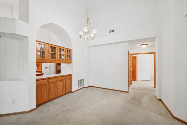 217 Canyon Dr, Hudson, WI 54016 - unfurnished dining area featuring a towering ceiling, light carpet, and a chandelier