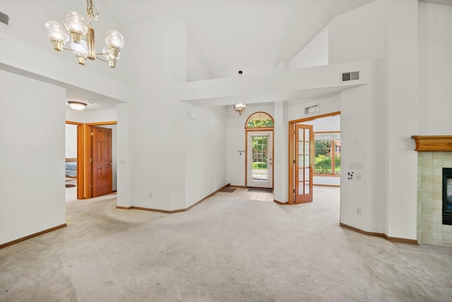 217 Canyon Dr, Hudson, WI 54016 - unfurnished living room featuring a chandelier, high vaulted ceiling, carpet flooring, and a tiled fireplace