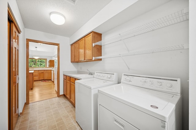 217 Canyon Dr, Hudson, WI 54016 - laundry room with washing machine and clothes dryer, cabinet space, light flooring, and a textured ceiling